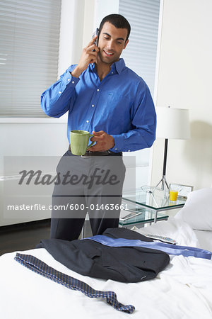 Man Using Cell Phone in Bedroom