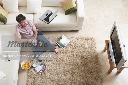 Mann vor dem Fernseher im Wohnzimmer