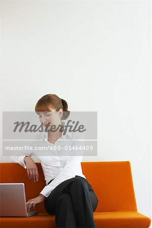 Geschäftsfrau auf Sofa mit Laptop-Computer