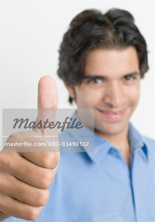 Portrait d'un jeune homme montrant thumbs up sign