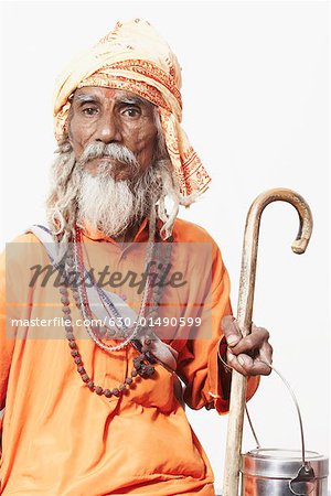 Porträt von einem Sadhu hält einen Stock und ein utensil