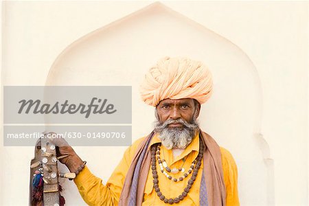 Portrait of a senior man holding a sitar