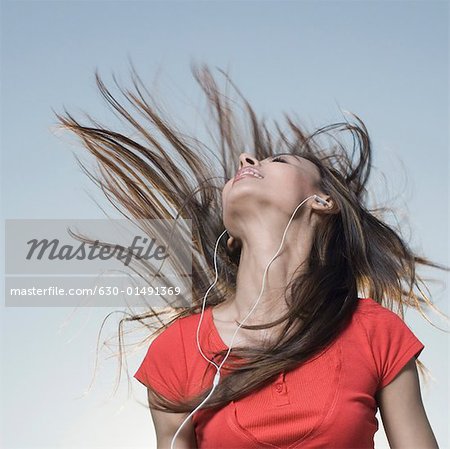 Low angle view of a young woman listening to music