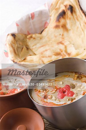 Gros plan de pains indiens servis au curry et lait caillé