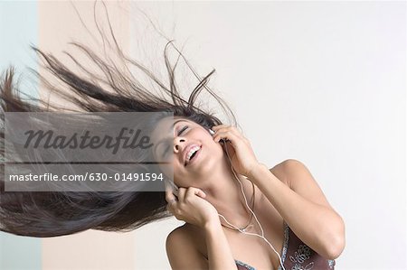 Young woman wearing headphones and listening to music