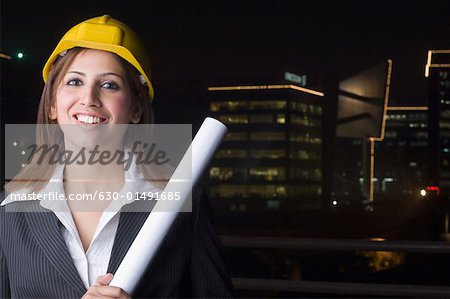 Porträt eines weiblichen Architekten holding eine Blaupause und Lächeln
