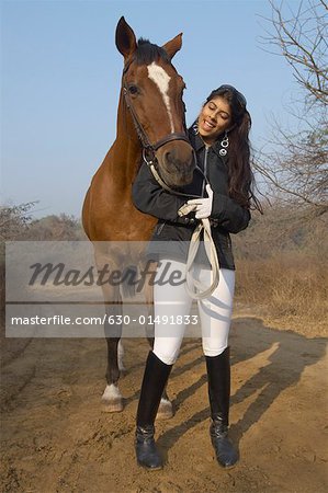 Junge Frau mit einem Pferd stehend