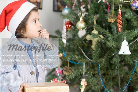 Close-up of a boy looking at a Christmas tree