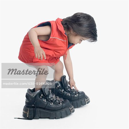 Side profile of a boy wearing oversized hiking boots