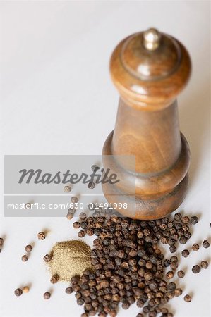 Close-up of a peppermill and peppercorns