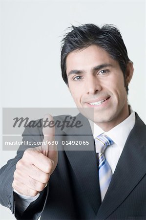 Porträt eines Kaufmanns ein Daumen hoch Zeichen anzeigen und Lächeln