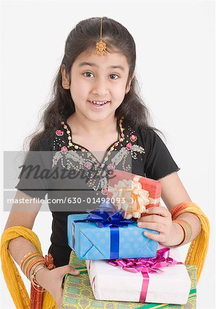 Portrait of a girl in traditional clothing holding gifts