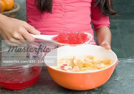 Mid section view of a girl making custard