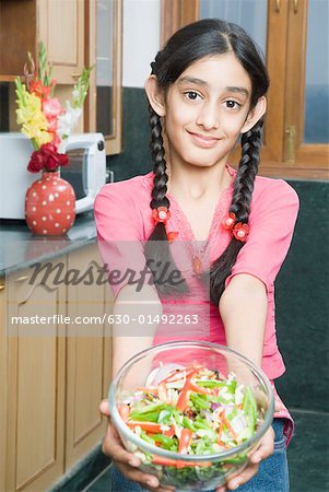 Portrait of a girl holding a bowl of salad