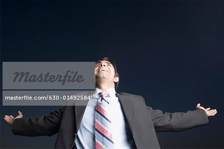 Low angle view of a businessman smiling with his arms outstretched