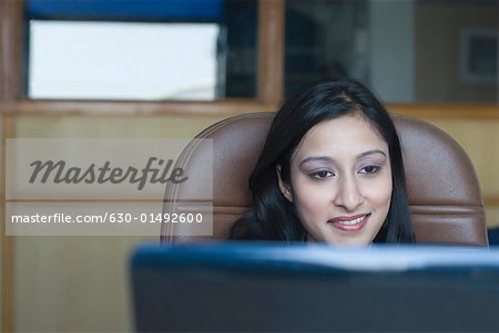 Close-up of a businesswoman sitting in front of a laptop and smiling