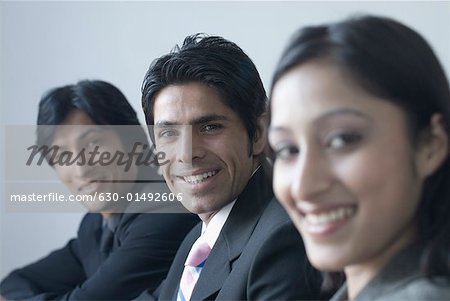 Porträt einer geschäftsfrau und zwei Geschäftsleute lächelnd