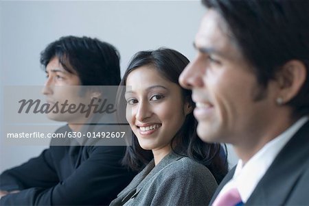 Portrait of a businesswoman and two businessmen smiling