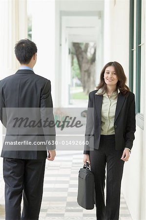 Portrait d'une femme d'affaires et un homme d'affaires marchant dans le couloir