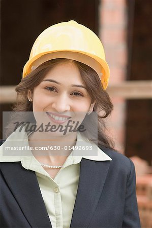 Portrait d'une femme d'affaires portant un casque protecteur et souriant