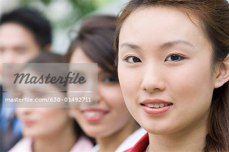 Portrait of a businesswoman smiling with her colleagues behind her