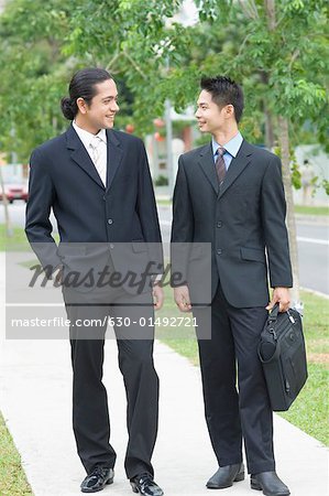 Zwei Geschäftsleute suchen einander an und Lächeln