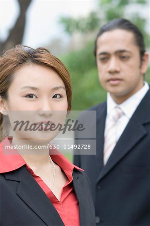 Portrait d'une femme d'affaires souriant avec un homme d'affaires debout à côté d'elle