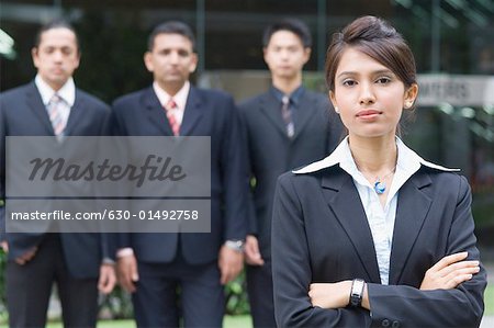 Portrait of a businesswoman with three businessmen standing behind her