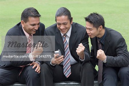 Three businessmen making a fist in excitement