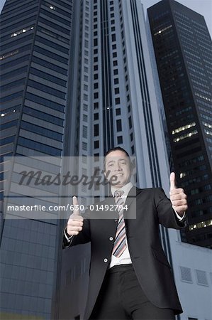 Portrait of a businessman showing thumbs up sign and smiling