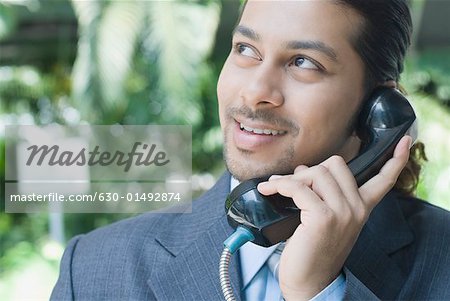 Close-up of a businessman talking on a pay phone