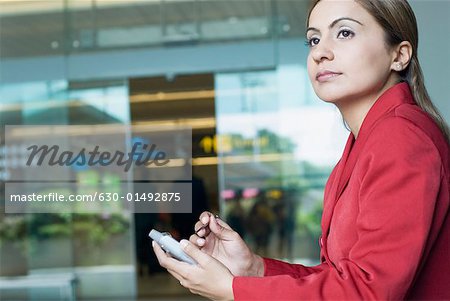 Side profile of a businesswoman using a personal data assistant