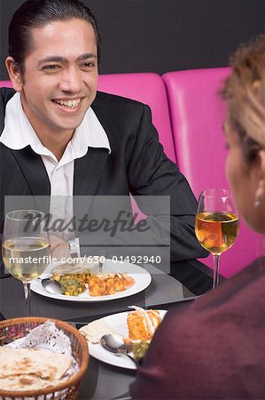 Mid homme adulte et une jeune femme assise à une table dans un restaurant