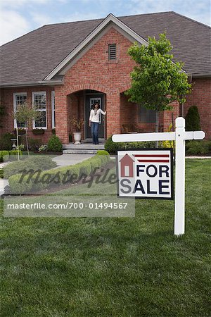 Portrait of Woman by House with Sold Sign