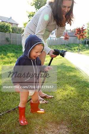 Mère et fils, arroser le gazon