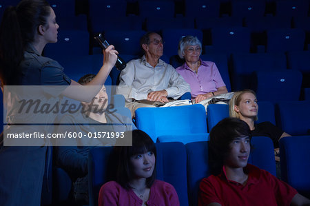 Usher Shining Light on Empty Seat in Movie Theatre