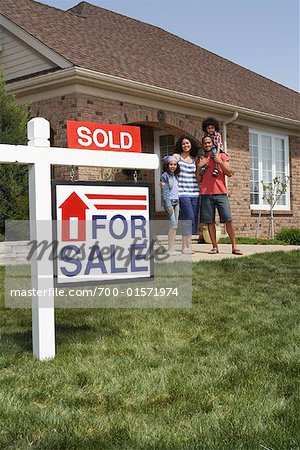 Portrait de famille par maison avec signe vendu