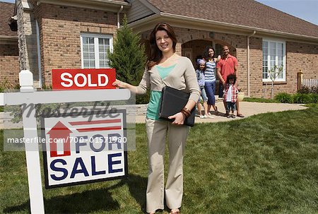 Real Estate Agent by Sold Sign