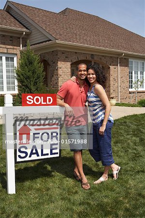 Couple by Sold Sign