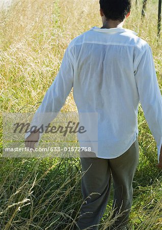 Homme marchant dans le champ vue arrière