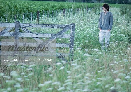 Adolescent marchant sur le terrain, écouter les écouteurs