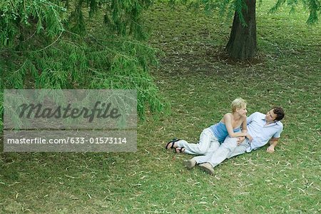 Paar im Gras, Lächeln einander, in voller Länge, erhöhte Ansicht liegend