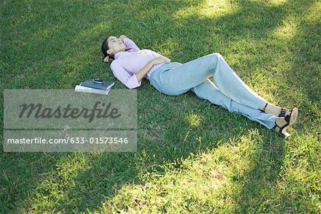 Geschäftsfrau, liegend im Gras, Augen geschlossen
