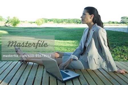 Businesswoman sitting on deck with laZSop