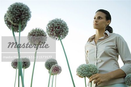 Frau stehend mit Allium Blumen