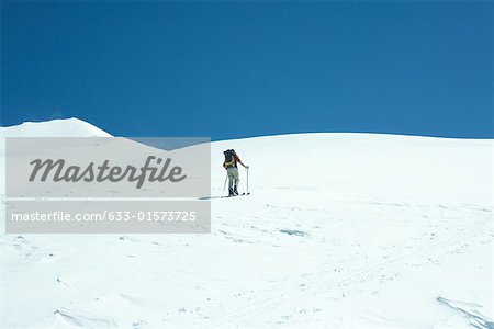 Skier going uphill, rear view