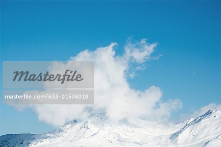 Snow-capped mountain surrounded by clouds