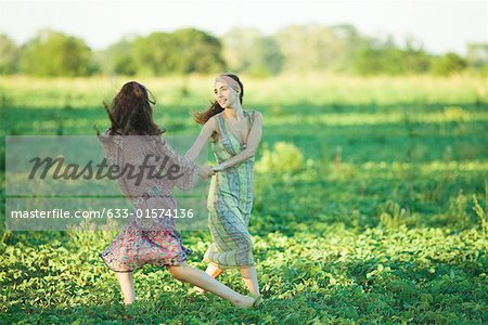 Young hippie women dancing in field