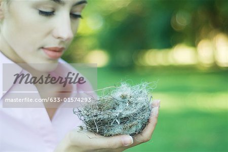 Femme tenant des nids d'hirondelle dans la paume de la main