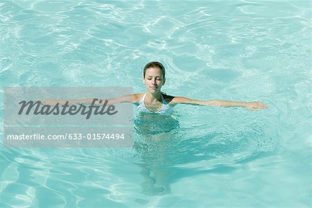 Junge Frau im Pool mit Armen heraus und geschlossenen Augen